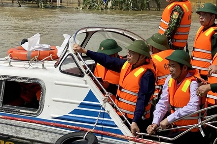 Bộ trưởng Nông nghiệp và Phát triển nông thôn, Phó Ban chỉ đạo T.Ư về Phòng chống thiên tai Nguyễn Xuân Cường đi cano kiểm tra vùng lũ Lệ Thủy, Quảng Bình ngày 22-10. Ảnh: HƯƠNG GIANG.