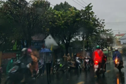 Mưa gió tại Kon Tum vào 8 giờ sáng 28-10 do ảnh hưởng của bão số 9. Phụ huynh đang đón học sinh trở về nhà tránh bão. Ảnh: HOÀNG PHÚC THẮNG.