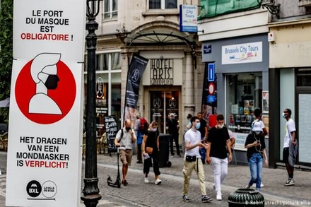 Người dân đeo khẩu trang khi di chuyển trên đường phố Brussels, Bỉ. (Ảnh: DW)