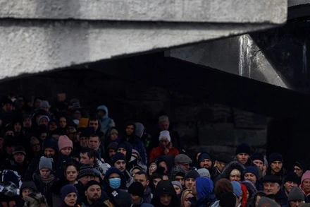 Người dân Ukraine chờ qua sông khi sơ tán khỏi thành phố Irpin, phía tây bắc thủ đô Kiev, ngày 8/3/2022. (Ảnh: REUTERS)