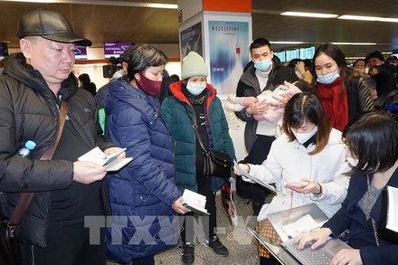 Cán bộ Đại sứ quán Việt Nam tại Ba Lan hỗ trợ thủ tục lên máy bay cho kiều bào sơ tán từ Ukraine. (Ảnh: TTXVN) 