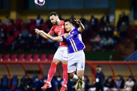 Việt Anh tranh bóng với tiền vệ Pinto Bruno. (Ảnh: TRẦN HẢI)