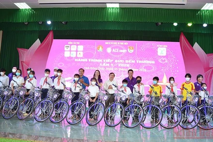 Các đồng chí Phan Văn Thắng, Huỳnh Minh Thức, cùng thành viên Câu lạc bộ ACE Charity trao tặng xe đạp cho học sinh. (Ảnh: HỮU NGHĨA)