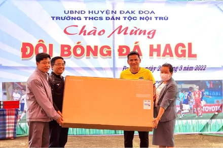 Ông Nguyễn Tấn Anh, Giám đốc điều hành và Huấn luyện viên Trưởng Kiatisuk trao quà tặng Trường THCS Dân tộc nội trú huyện Đắk Đoa.