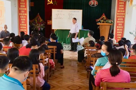 Trưởng bản Phan Thanh Tuyền dạy tiếng Mường cho người dân.