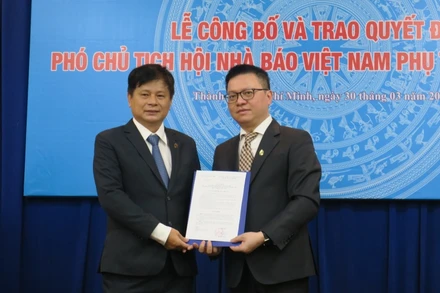 Đồng chí Lê Quốc Minh, Ủy viên Trung ương Đảng, Tổng Biên tập Báo Nhân Dân, Phó Trưởng Ban Tuyên giáo Trung ương, Chủ tịch Hội Nhà báo Việt Nam, trao quyết định cho ông Trần Trọng Dũng.