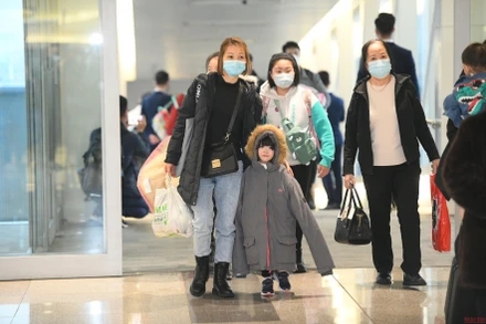 Những hành khách đầu tiên xuất hiện tại sân bay Nội Bài sau hành trình kéo dài hơn 10 tiếng từ Warsaw (Ba Lan) về nước. (ẢNH: THÀNH ĐẠT)