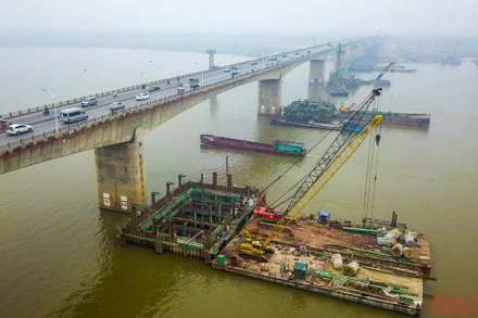 Nhà thầu đã huy động sà lan 1.000-2.000 tấn và 4 giàn khoan cùng hệ nổi để thi công phần móng cọc ở dưới lòng sông Hồng. (Ảnh: THÀNH ĐẠT) 