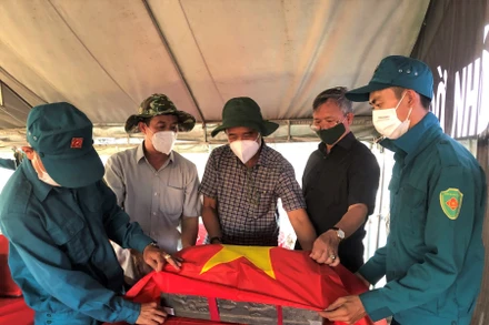 Đồng chí Cao Tiến Dũng cùng thành viên Ban Chỉ đạo 515 phủ Quốc kỳ lên quách hài cốt liệt sĩ.