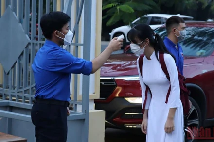 Đo thân nhiệt cho học sinh trước khi vào lớp học trực tiếp tại Đồng Nai. 