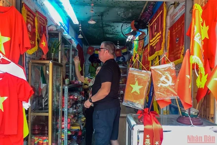 Du khách nước ngoài thích thú với các sản phẩm liên quan đến SEA Games 31. (Ảnh: Ngọc Lan)