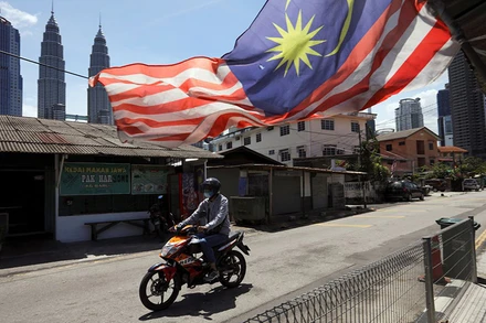 Người đàn ông đeo khẩu trang khi tham gia giao thông tại Kuala Lumpur trong thời gian thành phố này bị phong tỏa để chống Covid-19, ngày 2/2/2021. (Ảnh: Reuters)