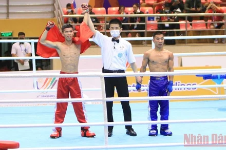 Huỳnh Văn Tuấn của đội Kickboxing Việt Nam (bên trái) giành chiến thắng trước đối thủ Lào.