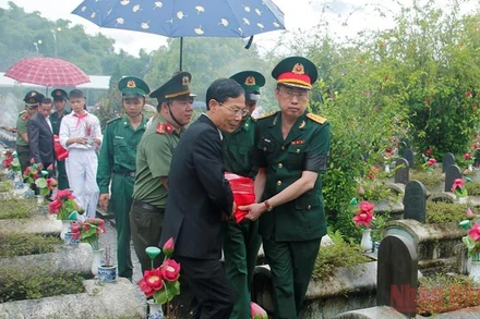 Các đại biểu di chuyển hài cốt liệt sĩ về nơi an táng.