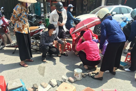 Hình ảnh một số người dân mang dụng cụ ra "xếp lốt" tại khu vực sân vận động Cẩm Phả trong sáng 20/5. (Nguồn: Internet)