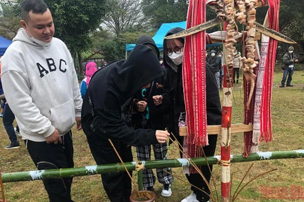 Du khách uống thử rượu cần tại Nhà người Ba Na trong dịp đầu năm mới.