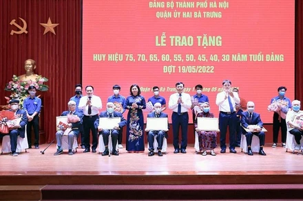 Phó Bí thư Thường trực Thành ủy Hà Nội Nguyễn Thị Tuyến trao Huy hiệu 75 năm tuổi Đảng cho các đảng viên quận Hai Bà Trưng. 