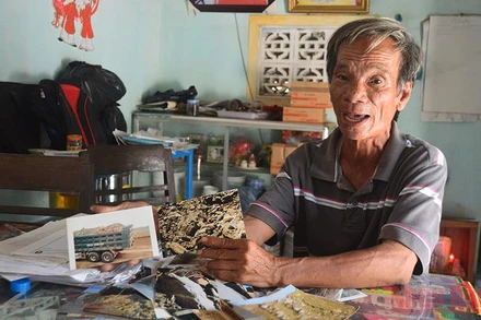 Ông Phạm Tấn Lực bên tập đơn tố cáo và hàng nghìn bức ảnh chứng cứ sai phạm.