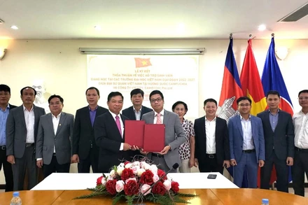 Đại sứ Nguyễn Huy Tăng và ông Phùng Văn Cường, Tổng Giám đốc Công ty Viettel Cambodia Pte.Ltd ký kết thỏa thuận. (Ảnh: Nguyễn Hiệp)