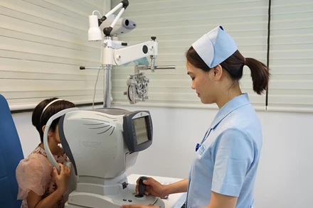 Nhân viên y tế khám, theo dõi các bệnh về mắt cho trẻ em. (Ảnh: PV/Vietnam+)
