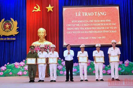 Chủ tịch Ủy ban nhân dân tỉnh Cà Mau (áo trắng) tặng Bằng khen cho các cá nhân phá nhanh các vụ trọng án. 