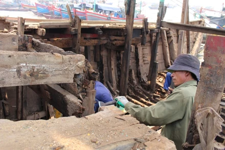 Người lao động ở xã Ngư Lộc, huyện Hậu Lộc tháo dỡ cấu kiện con tàu giải bản.