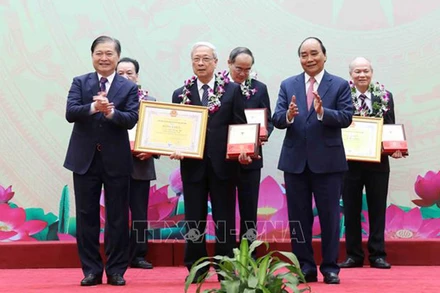 Chủ tịch nước Nguyễn Xuân Phúc và TS Khoa học Phan Xuân Dũng, Bí thư Đảng đoàn, Chủ tịch Liên hiệp các hội Khoa học và Kỹ thuật Việt Nam trao Danh hiệu "Tri thức khoa học và công nghệ tiêu biểu" và Bằng khen của Liên hiệp các hội Khoa học và Kỹ thuật Việt Nam cho các cá nhân. (Ảnh: An Đăng TTXVN)