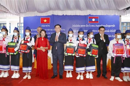 Chủ tịch Quốc hội Vương Đình Huệ tặng quà cho các cháu học sinh giỏi tại Trường phổ thông Dân tộc nội trú tỉnh Champasak (Lào), chiều 17/5. (Ảnh: TTXVN)