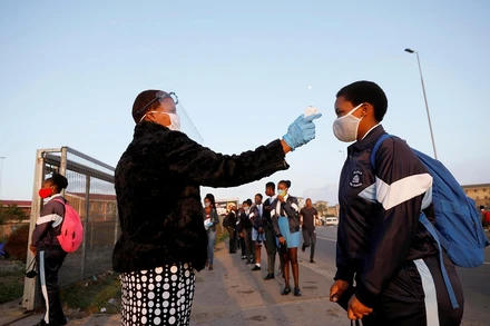 Kiểm tra thân nhiệt các học sinh trước khi vào lớp học ở thị trấn Langa, Cape Town, Nam Phi. (Ảnh: Reuters)
