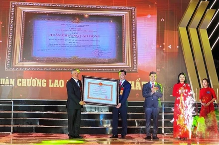 Đồng chí Nguyễn Hòa Bình (bên trái) Trao Huân chương Lao động hạng Nhất cho đại diện Đảng bộ, chính quyền và nhân dân huyện Hiệp Hòa.