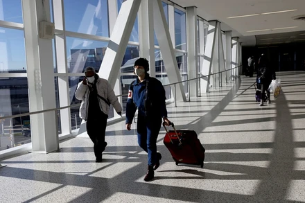 Hành khách đeo khẩu trang di chuyển tại sân bay quốc tế JFK ở New York, Mỹ, ngày 16/11/2021. (Ảnh: Reuters)