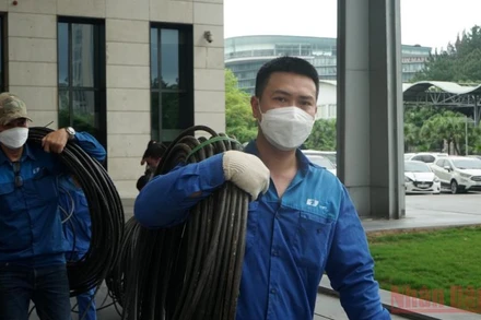 Anh Nguyễn Huy Ánh (bên phải) và đồng nghiệp thực hiện đấu nối đường tnternet đi quốc tế tại Trung tâm Hội nghị quốc gia.