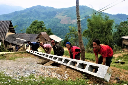 Người dân bản kim đa (Phà Đánh), giúp vận chuyển cột điện để đẩy nhanh tiến độ thi công