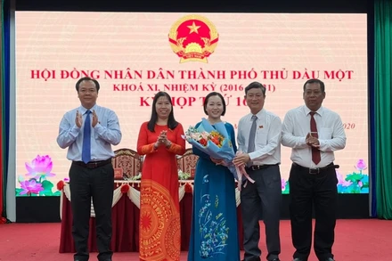 Phó Bí thư Thường trực Tỉnh ủy, Chủ tịch HĐND tỉnh Bình Dương Võ Văn Minh tặng hoa chúc mừng đồng chí Nguyễn Thu Cúc.