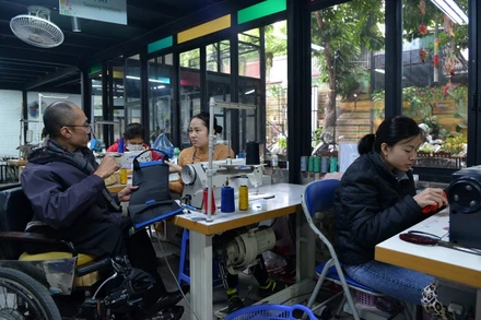 Anh Pham Việt Hoài trao đổi với nhân viên xưởng may về sản phẩm đang hoàn thiện.