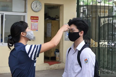 Đo thân nhiệt cho học sinh trước khi vào trường (Ảnh: THỦY NGUYÊN)