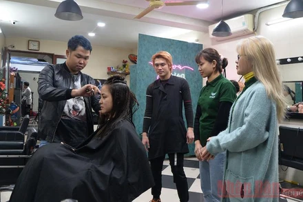 Anh Thái Thành hướng dẫn học viên một kiểu tạo mẫu tóc cho nữ giới. (Ảnh: Thủy Nguyên)