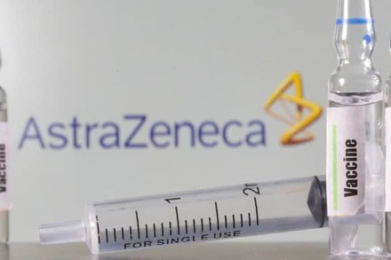 Một ống nghiệm dán nhãn vaccine được nhìn thấy phía trước logo AstraZeneca được chụp vào ngày 9-9-2020. Ảnh: Reuters.