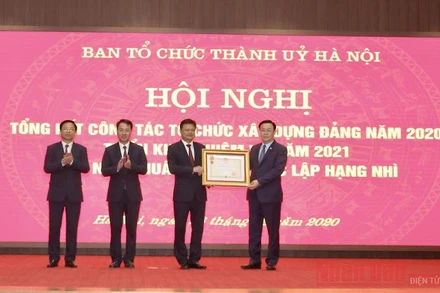 Đồng chí Vương Đình Huệ, Ủy viên Bộ Chính trị, Bí thư Thành ủy Hà Nội trao Huân chương Độc lập hạng Nhì cho Ban Tổ chức Thành ủy Hà Nội. (Ảnh: Duy Linh)