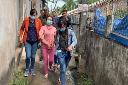 Đối tượng Lê Thị Bình (ở giữa, áo hồng) khi bị bắt. (Ảnh: Công an cung cấp)