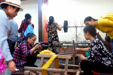 Khách hàng tham quan quy trình sản xuất lụa tơ tằm tại làng Vạn Phúc (quận Hà Đông).