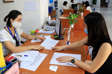 Cán bộ Cục Thuế Hà Nội hướng dẫn doanh nghiệp làm thủ tục hành chính (Ảnh minh họa).