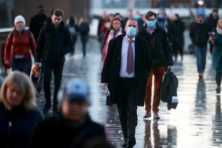 Người dân đi bộ qua cầu London ngày 15-12 khi Covid-19 tiếp tục lây lan ở Anh. Ảnh: Reuters.