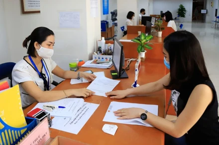 Cán bộ Cục Thuế Hà Nội hướng dẫn doanh nghiệp làm thủ tục hành chính.