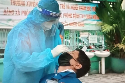 Lái xe công nghệ xét nghiệm nhanh tại Trường mầm non Vàng Anh, quận Gò Vấp sáng 31/8. (Ảnh: QUANG QUÝ)