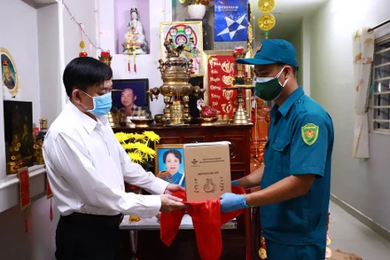 Bộ Tư lệnh TP Hồ Chí Minh là đơn vị được UBND TP giao phối hợp xử lý thi hài và tro cốt bệnh nhân Covid-19 tử vong trên địa bàn. Trong ảnh: Dân quân tự vệ bàn giao tro cốt cho một gia đình có người chết vì Covid-19 trên địa bàn thành phố.