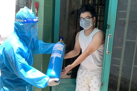 Trao bình oxy cho người nhà bệnh nhân điều trị cách ly tại nhà. 