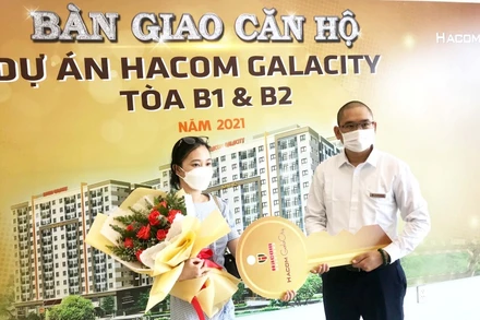 Đại diện chủ đầu tư trao chìa khóa và chúc mừng người có thu nhập thấp nhận căn hộ mới.