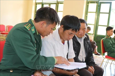 Chiến sĩ Đồn biên phòng Nậm Kè (Bộ đội Biên phòng tỉnh Điện Biên) trao đổi nội dung tuyên truyền, phổ biến pháp luật cho các trưởng bản. Ảnh: TTXVN.