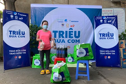 Người dân ở Liên khu 1-6, Bình Trị Đông, TP Hồ Chí Minh nhận quà hỗ trợ khẩn cấp của AFV và CARE quốc tế tại Việt Nam (Ảnh: AAV).